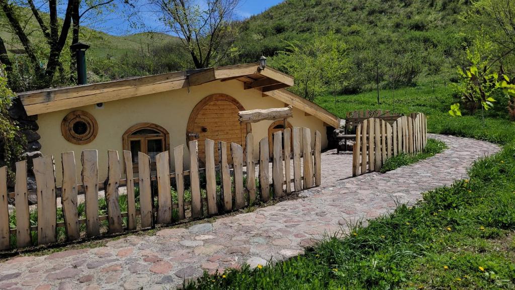 a small house with a wooden fence next to it at Jashylkent House in Vorontsovskoye