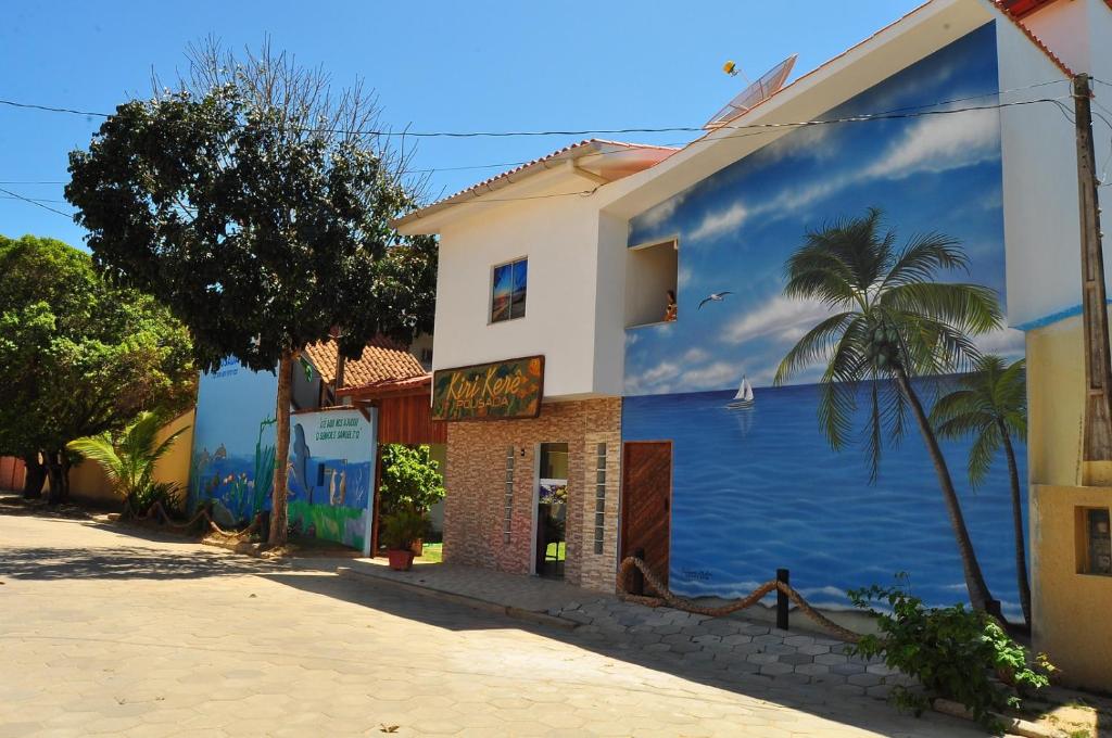 a building with a mural of the ocean on it at Pousada Kiri Kerê in Guriri
