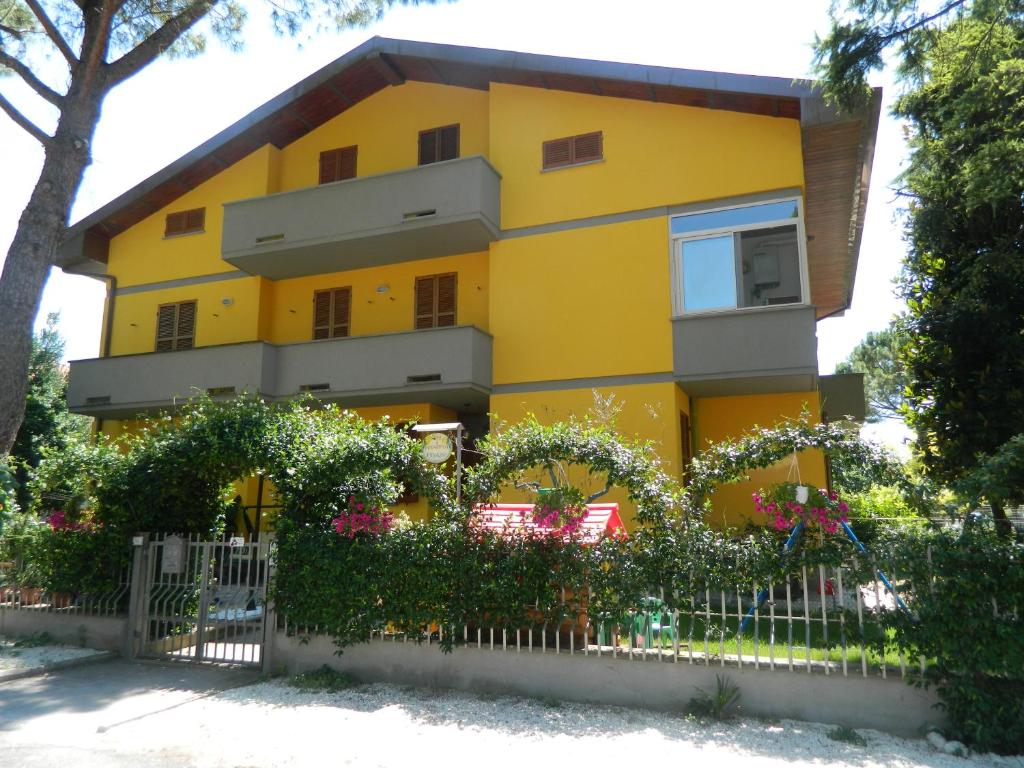 a yellow house with a fence in front of it at B&B I Narcisi in Spello