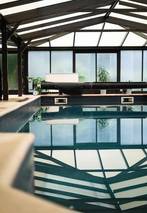 - une piscine d'eau dans une chambre avec fenêtres dans l'établissement Maison l Ônelle, à Quiévrechain