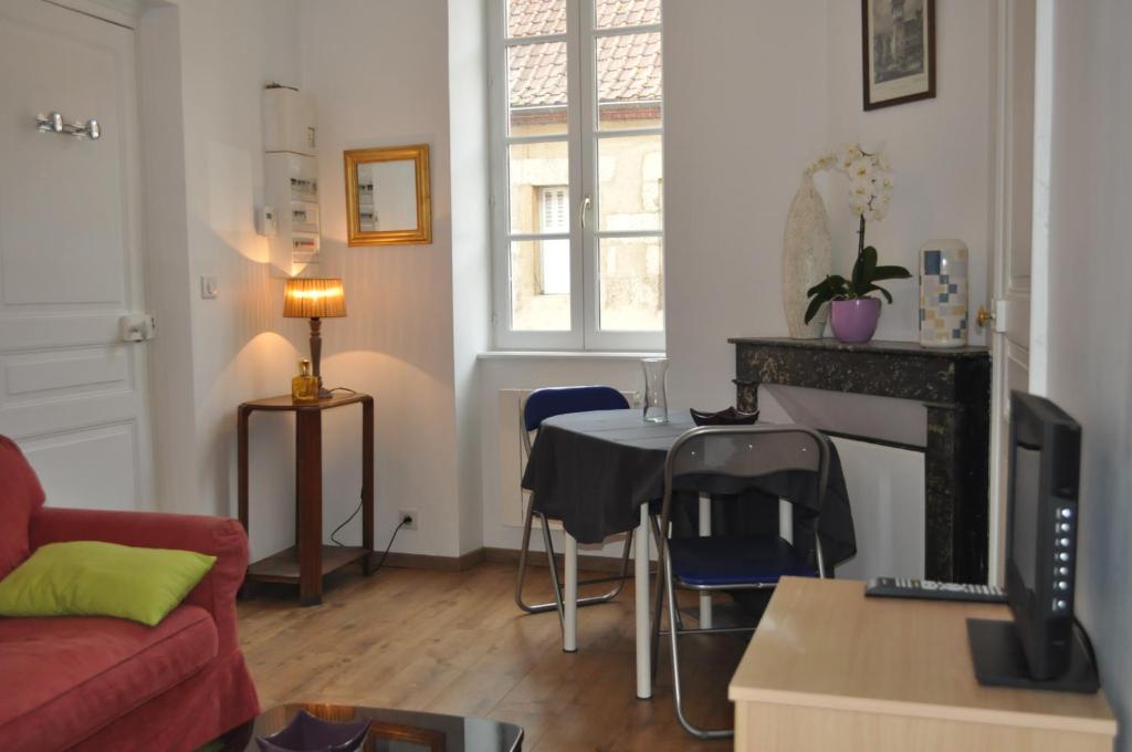 sala de estar con sofá y mesa con sillas en L'appartement d'Aymar, en Moulins