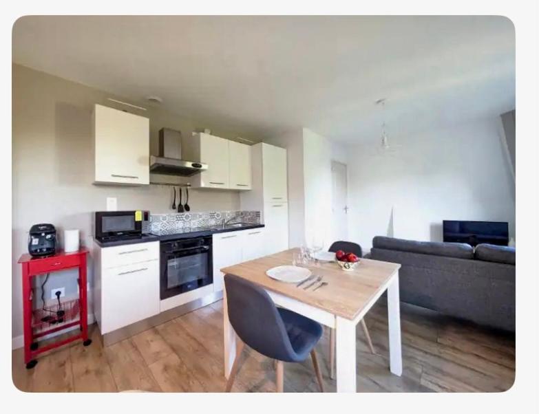 une cuisine et un salon avec une table et un canapé dans l'établissement Studio aux cœurs des remparts, à Gravelines