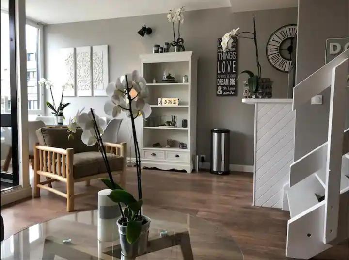 un salon avec un canapé et une chaise dans l'établissement Deauville les pieds dans l'eau, à Deauville