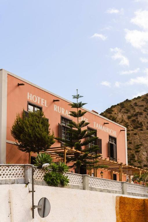 a hotel with trees in front of a building at Tamahuche Hotel Rural in Vallehermoso