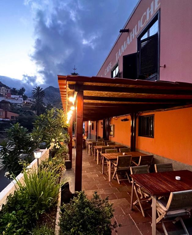 a restaurant with tables and chairs on a building at Tamahuche Hotel Rural in Vallehermoso