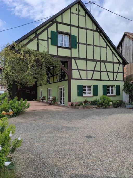 a large green and white house with a driveway at La grange de Manu in Richtolsheim