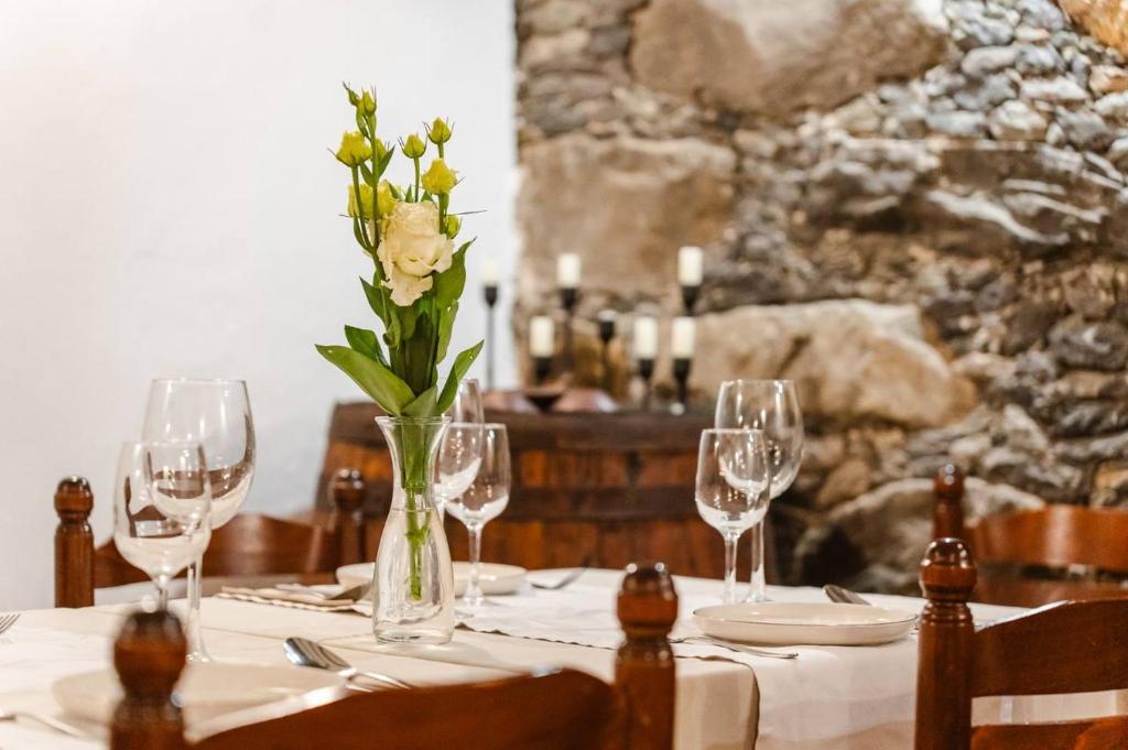 a table with glasses and a vase with a flower at Tamahuche Hotel Rural in Vallehermoso