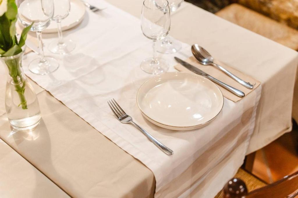 a table with white plates and silverware on it at Tamahuche Hotel Rural in Vallehermoso
