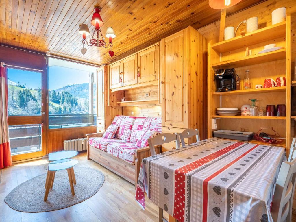 une chambre avec un lit et un canapé dans une pièce dans l'établissement Charmant Studio avec Balcon et Proximité Commerces - FR-1-304-88, à La Clusaz