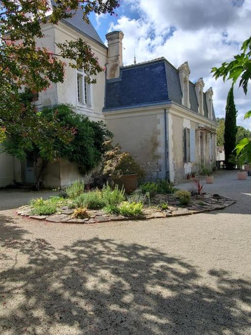 une grande maison blanche avec un jardin en face de celle-ci dans l'établissement La Grelauderie 8, à Saintes