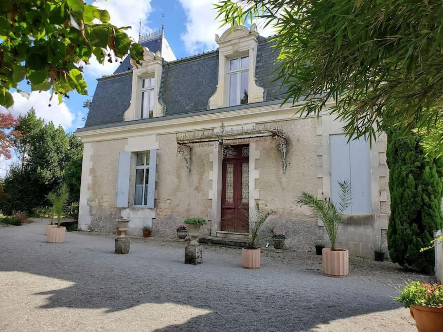 サントにあるLa Grelauderie 8の赤い扉と鉢植えの白い家