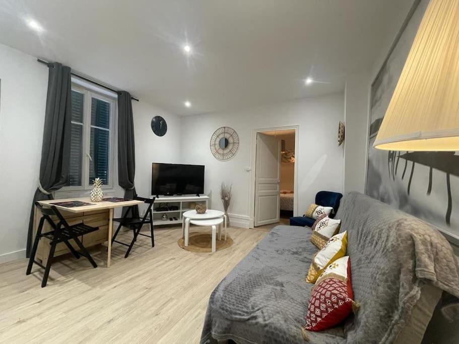 un salon avec un canapé et une table dans l'établissement Appartement neuf chic urbain, à Dijon