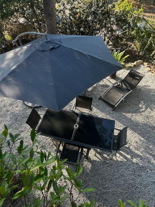 un parasol bleu assis sur une table avec des chaises dans l'établissement Très joli appartement Saint-Raphaël, à Saint-Raphaël