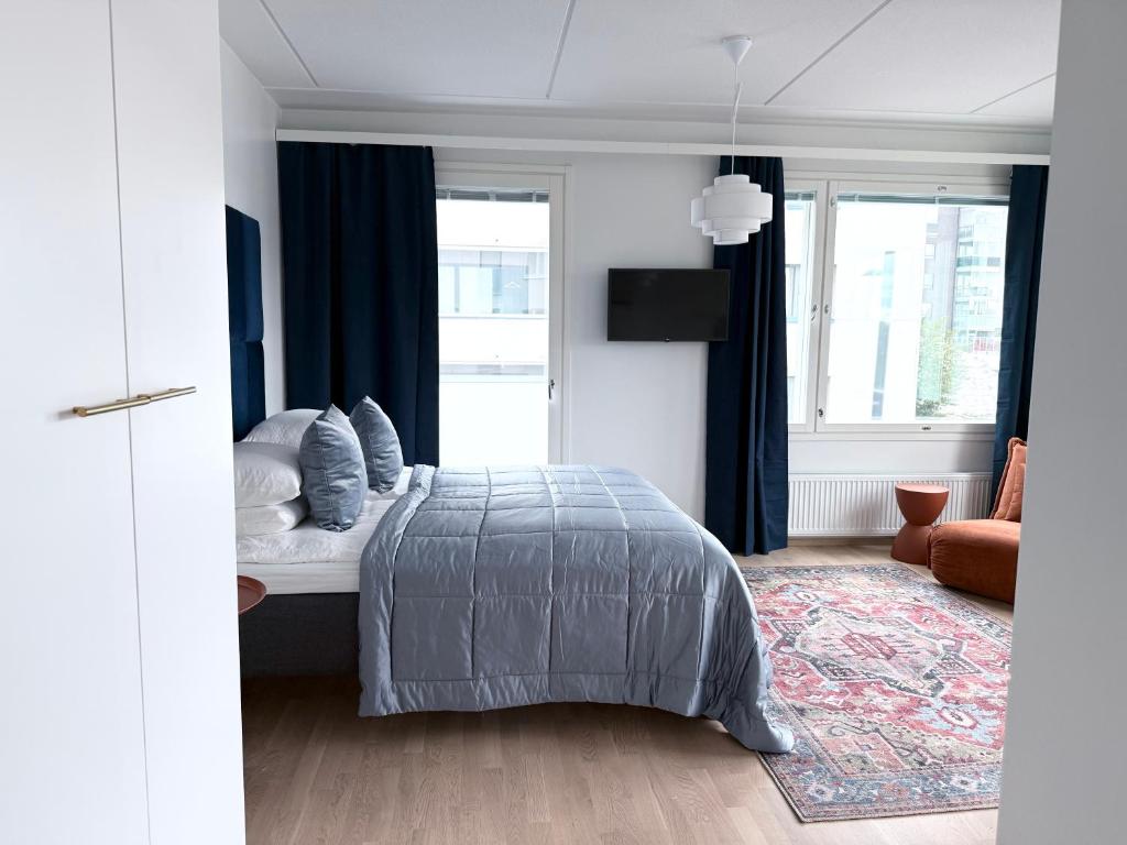 a bedroom with a bed with pillows on it at Spacious Railway Station Apartment in Oulu
