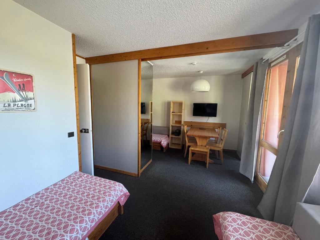 une chambre d'hôtel avec un lit et une table à manger dans l'établissement Studio divisible fonctionnel au pied des pistes avec balcon - FR-1-181-2280, à La Plagne Tarentaise