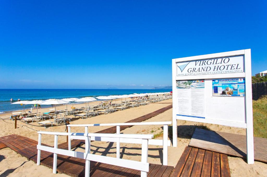 a sign on a beach with chairs and the ocean at Virgilio Grand Hotel in Sperlonga