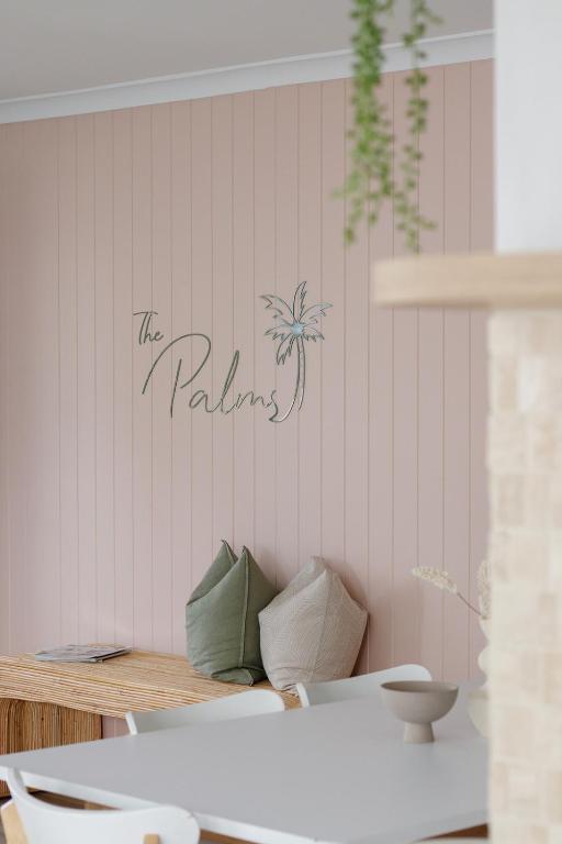a wall with a palm tree sign on it at Palms on Tugun in Gold Coast