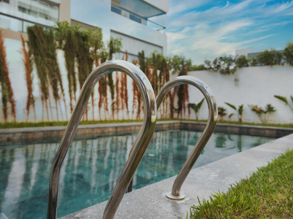Sancy Luxury rez de jardin avec piscine privée في الدار البيضاء: درج معدني يؤدي إلى حمام السباحة