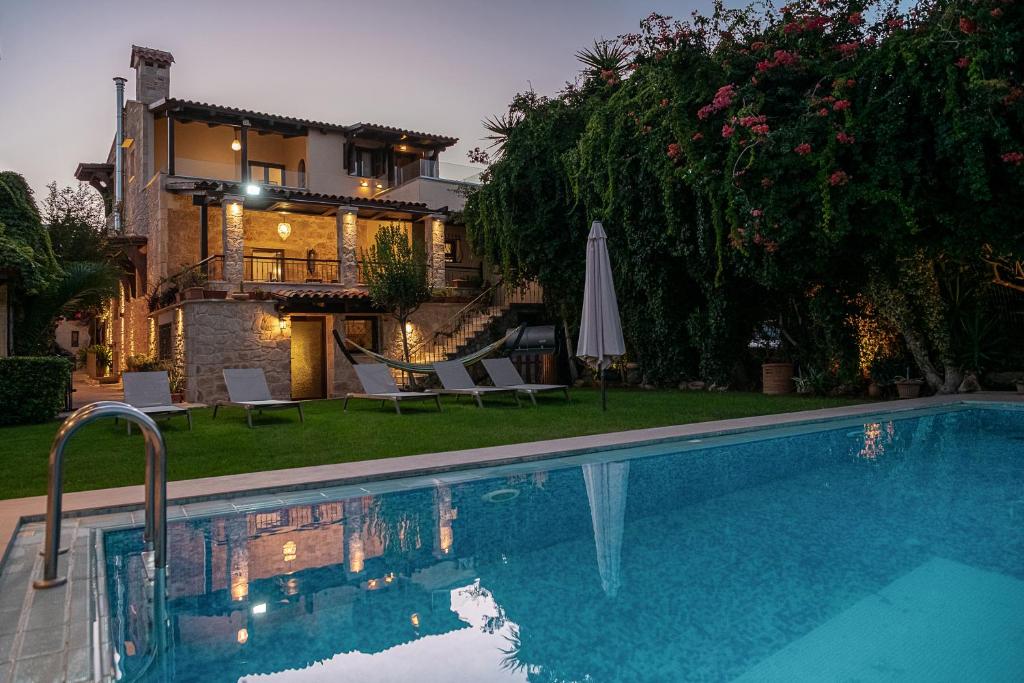 a house with a swimming pool in front of a house at Villa Arhontariki in Kissamos