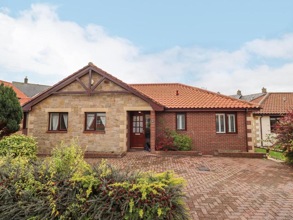 a brick house with a brick driveway at Rokeby in Bamburgh