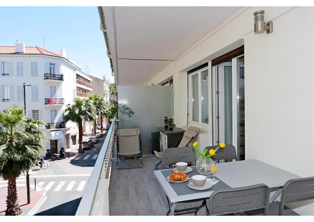 un balcon avec une table et des chaises sur un immeuble dans l'établissement T2 centre-ville Banane à Cannes avec grande terrasse, à Cannes