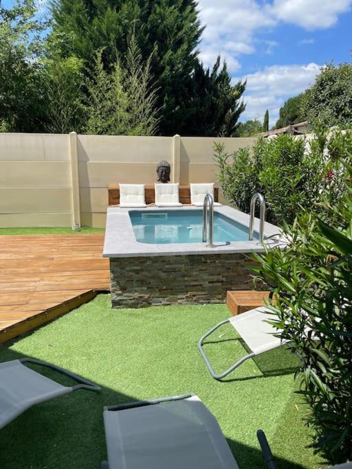 une piscine dans une cour avec une pelouse sidx sidx sidx dans l'établissement Maison avec petite piscine Arcachon Bordeaux, à Mios