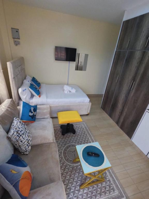 a living room with a couch and a bed at Ravic Homes Studio in Nairobi