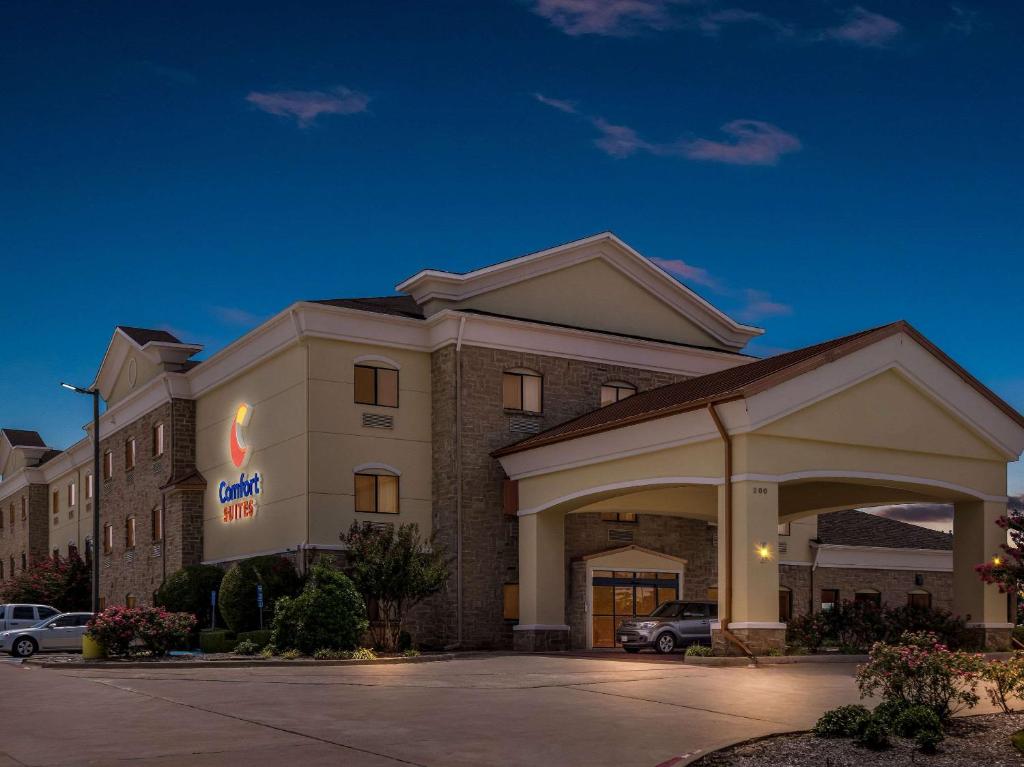 a hotel with a sign on the front of a building at Comfort Suites Lindale in Lindale