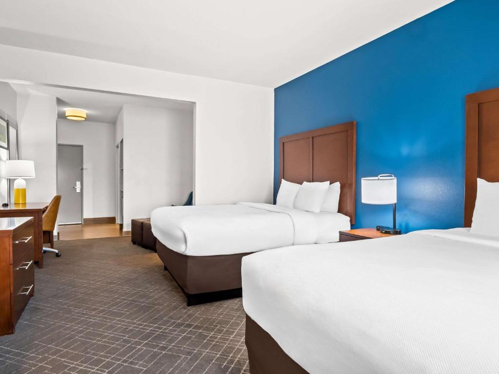 a hotel room with two beds and a blue wall at Comfort Suites Lindale in Lindale