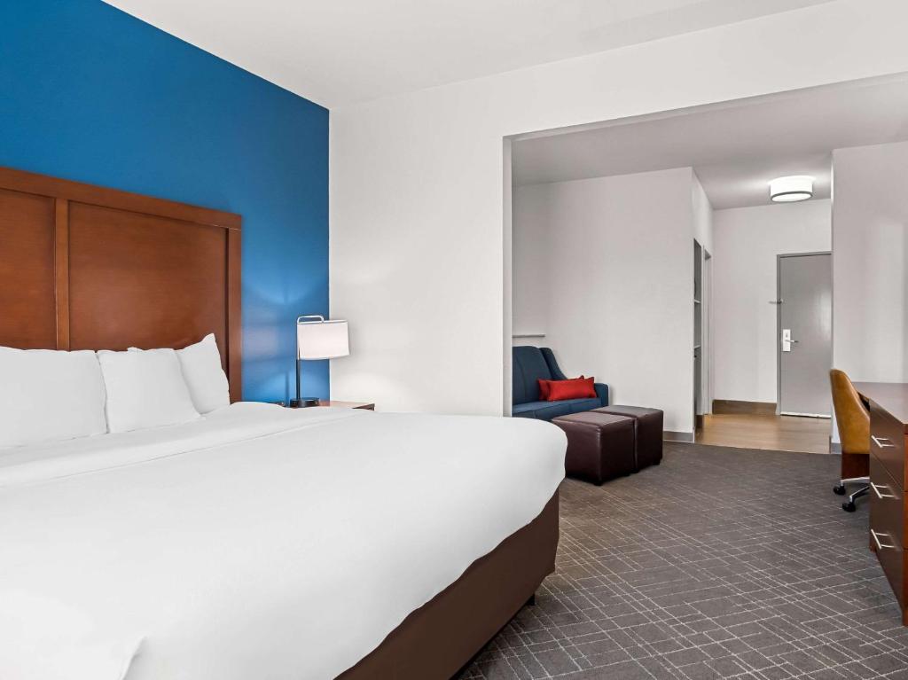 a hotel room with a large bed and a couch at Comfort Suites Lindale in Lindale