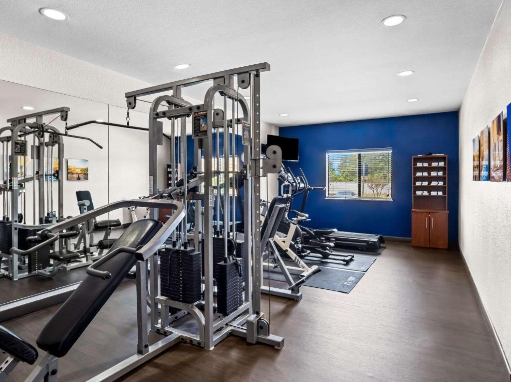 a gym with several tread machines and a blue wall at Comfort Suites Lindale in Lindale