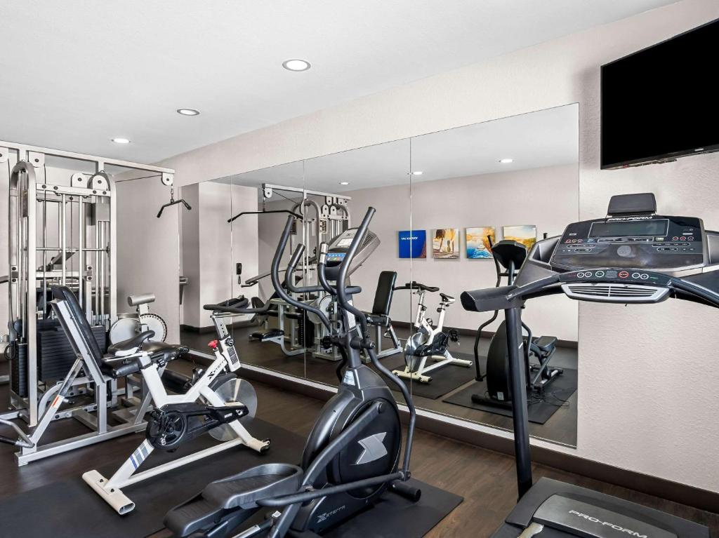 a gym with several exercise bikes and a flat screen tv at Comfort Suites Lindale in Lindale