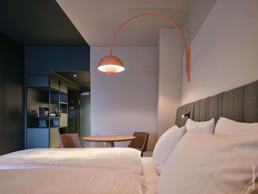a hotel room with a bed and a table at Dorint Hotel Bonn in Bonn
