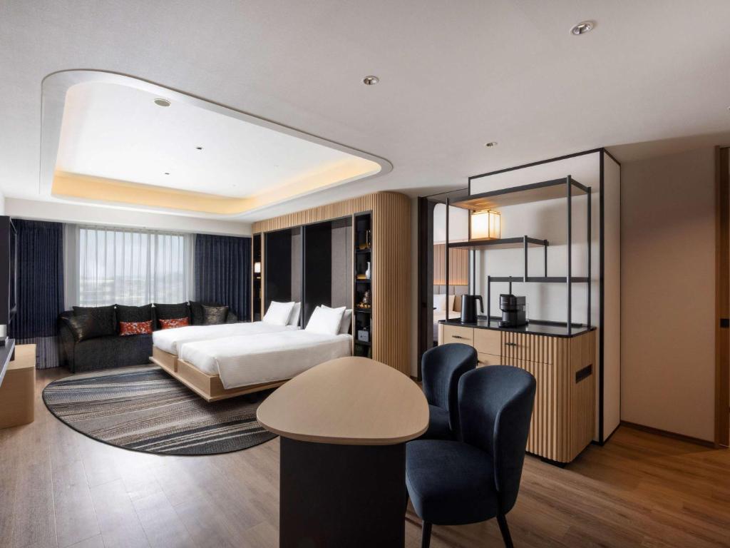 a hotel room with a bed and a living room at Novotel Nara in Nara