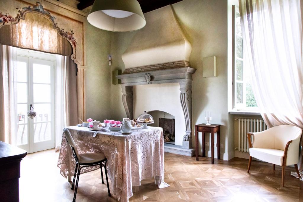 a dining room with a table and a fireplace at B&B Dimora Delle Donnole Bergamo Alta in Bergamo