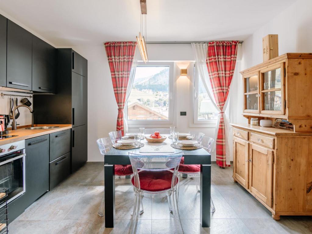 a kitchen with a table and chairs and a window at Apartment Family House by Interhome in Moena