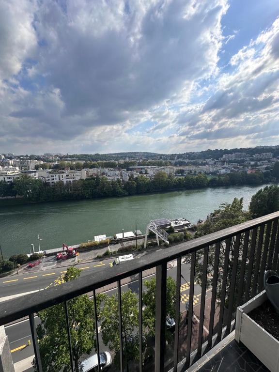 d'un balcon avec vue sur la rivière. dans l'établissement Superbe appartement vue sur la Seine situé à Boulogne-Billancourt, à Boulogne-Billancourt