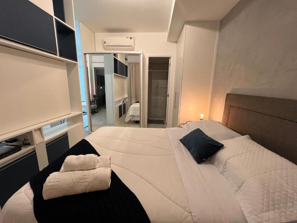 a bedroom with a large white bed with towels on it at Habitarte Brooklin in Sao Paulo