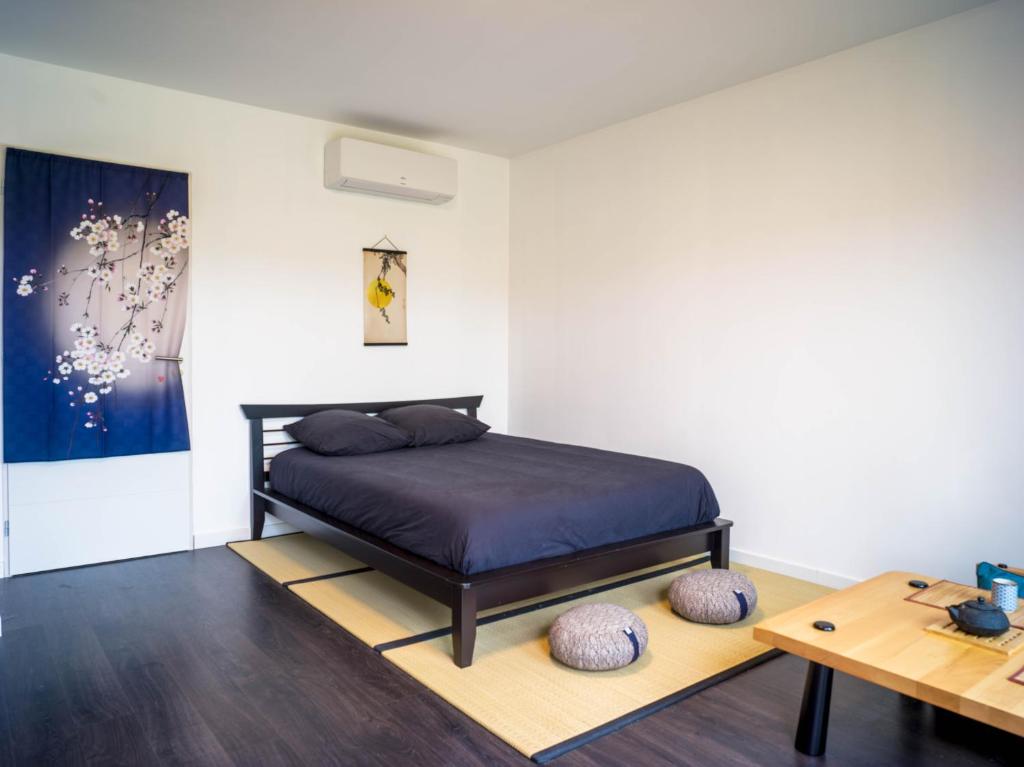 a bedroom with a bed and a table at Kitsuné Lodge zen d'inspiration japonaise in Chaintré