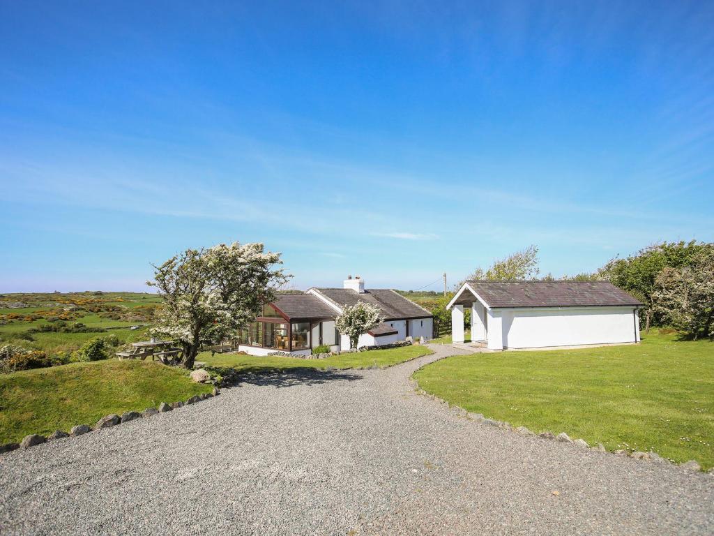 a home with a gravel driveway and a house at Ty Mynydd in Holyhead