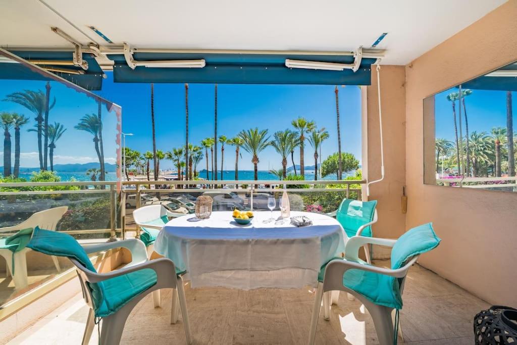 une table et des chaises sur un balcon avec vue sur l'océan dans l'établissement Croisette vue mer 2 pièces, à Cannes