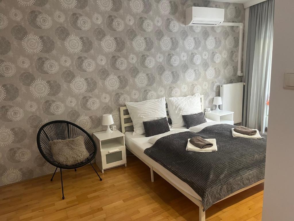 a bedroom with a bed and a chair and a wall at Peter's Cosy Budapest Suite in Budapest