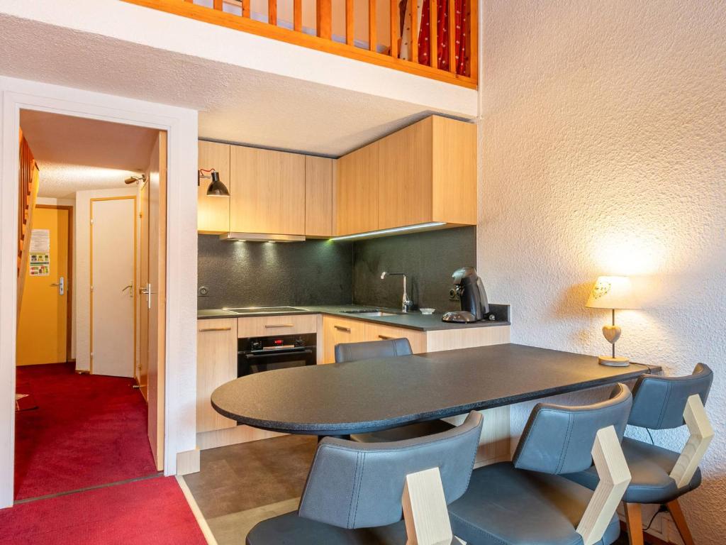- une cuisine avec une table et des chaises bleues dans l'établissement Centre Val d'Isère - Proche neige et commerces, appartement 4-6 pers. - FR-1-519-19, à Val dʼIsère