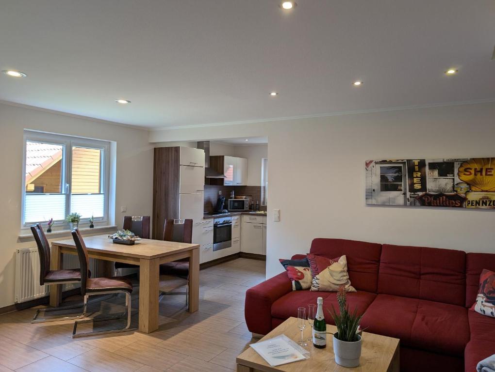 a living room with a red couch and a table at Ferienhaus Ostara in Hasselfelde