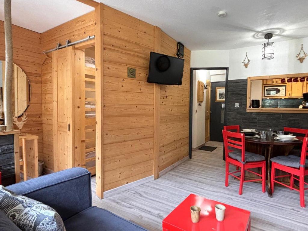 un salon avec une table et des chaises rouges dans l'établissement Appartement rénové 2 pièces, accès direct aux pistes et proche centre station - FR-1-634-75, à Morzine