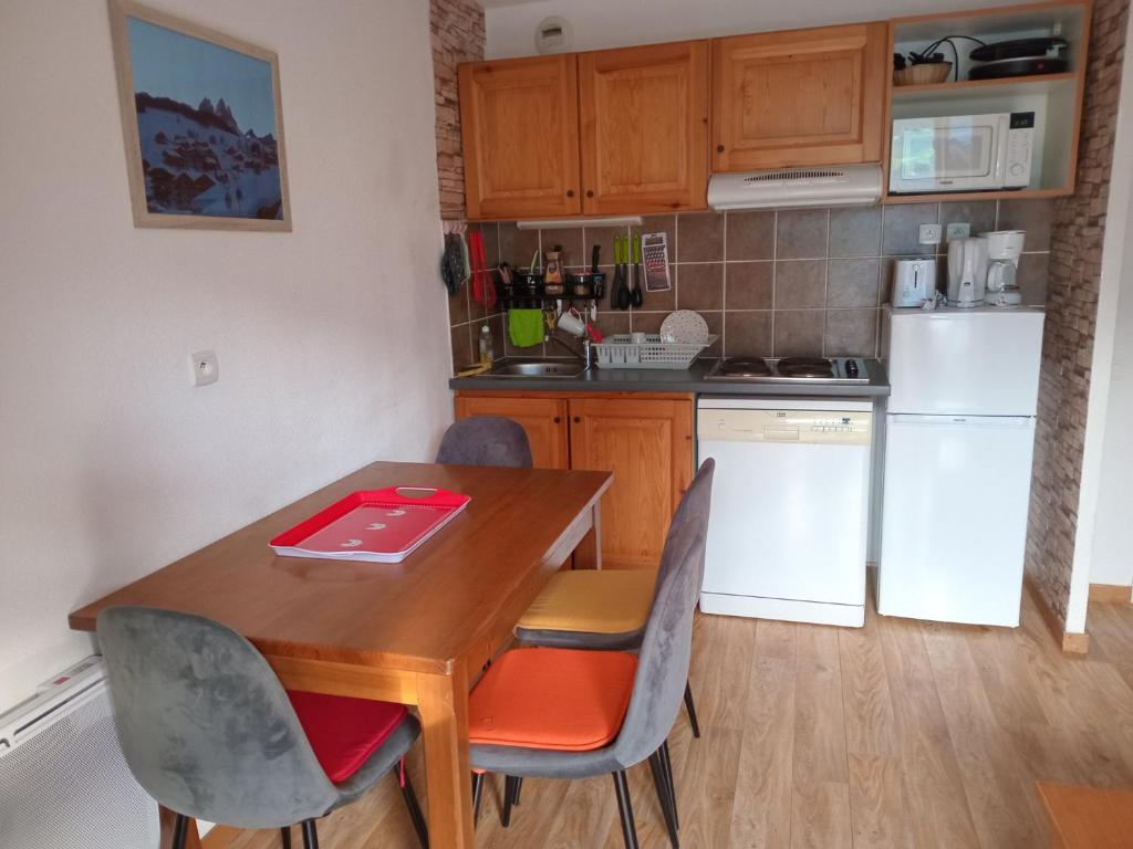 une petite cuisine avec une table et des chaises en bois dans l'établissement Appartement confortable, 300m des pistes et commerces, balcon sud, parking, animaux acceptés - FR-1-618-14, à Albiez-Montrond