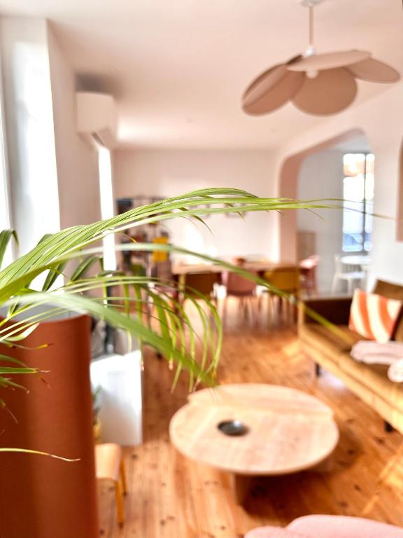 un salon avec une table et une plante dans l'établissement Villa Lucie, 4 à 8 personnes, à Clermont-Ferrand