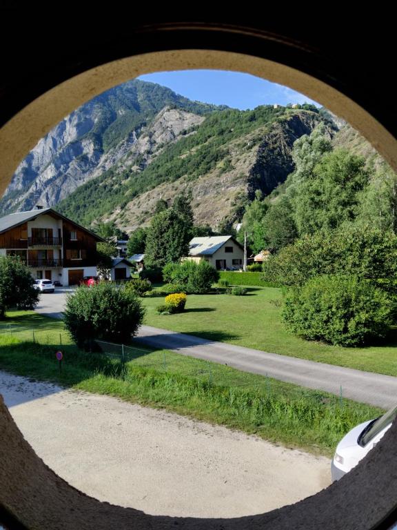 - une vue sur la montagne depuis une fenêtre ronde dans l'établissement Studio au pied de l'alpe d'huez, au Bourg-dʼOisans