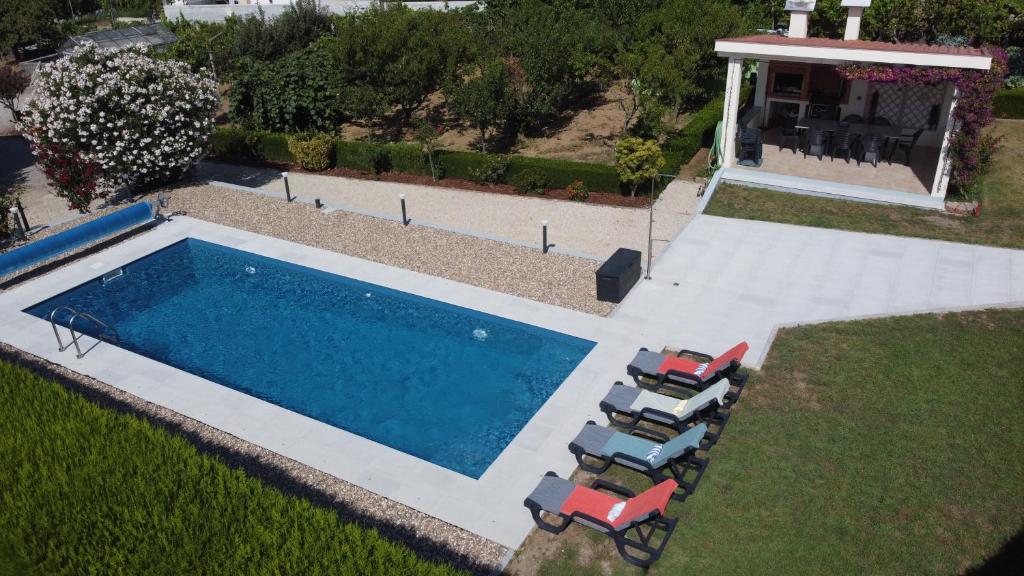 an overhead view of a swimming pool with chairs and a house at Pooltugal House in São Romão