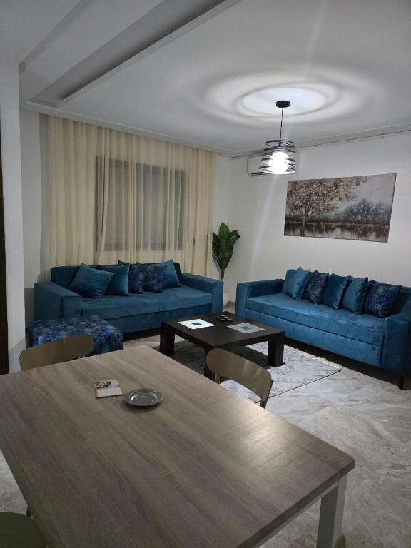 a living room with blue couches and a table at Luxury apartment in Ariana